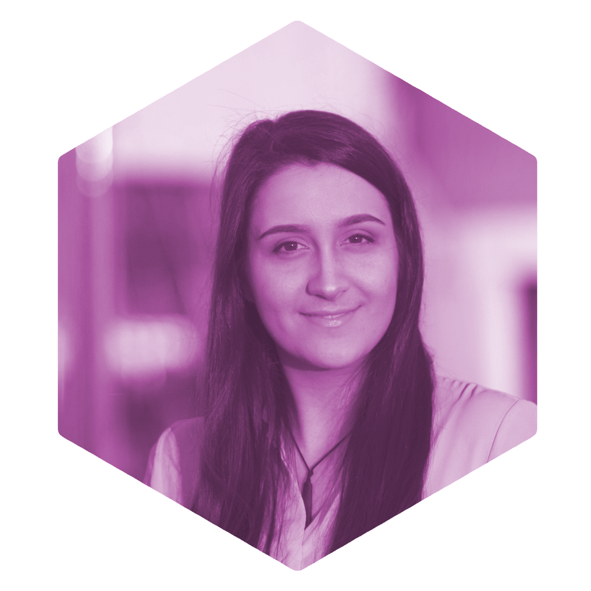 Kera Sherwood-O'Regan photographed by Jason Boberg. She has long brown hair, is wearing a pale shirt and pounamu, and is smiling slightly at the camera.